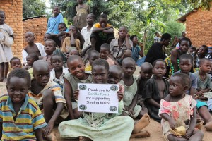 Children at Nakisenyi village with Gorilla Tours sign